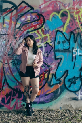 站在涂鸦墙的时髦纹身美女图片